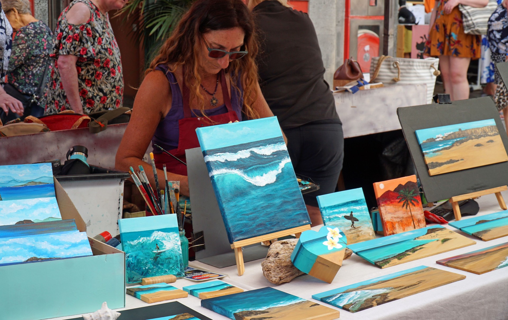 Lady selling  her seascape paintings at craft market