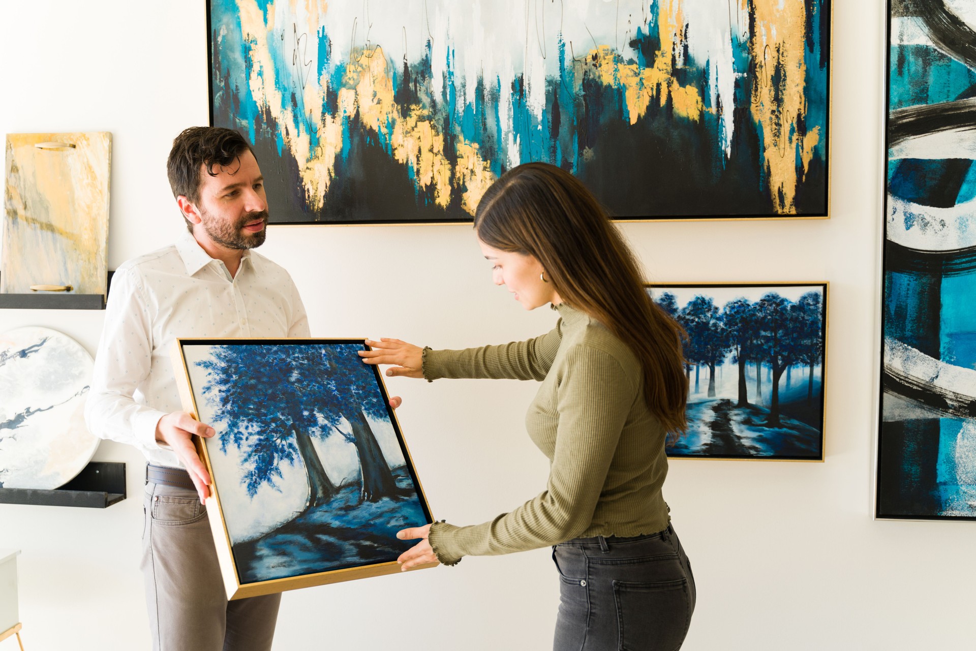 Painter holding his painting to show it to a customer